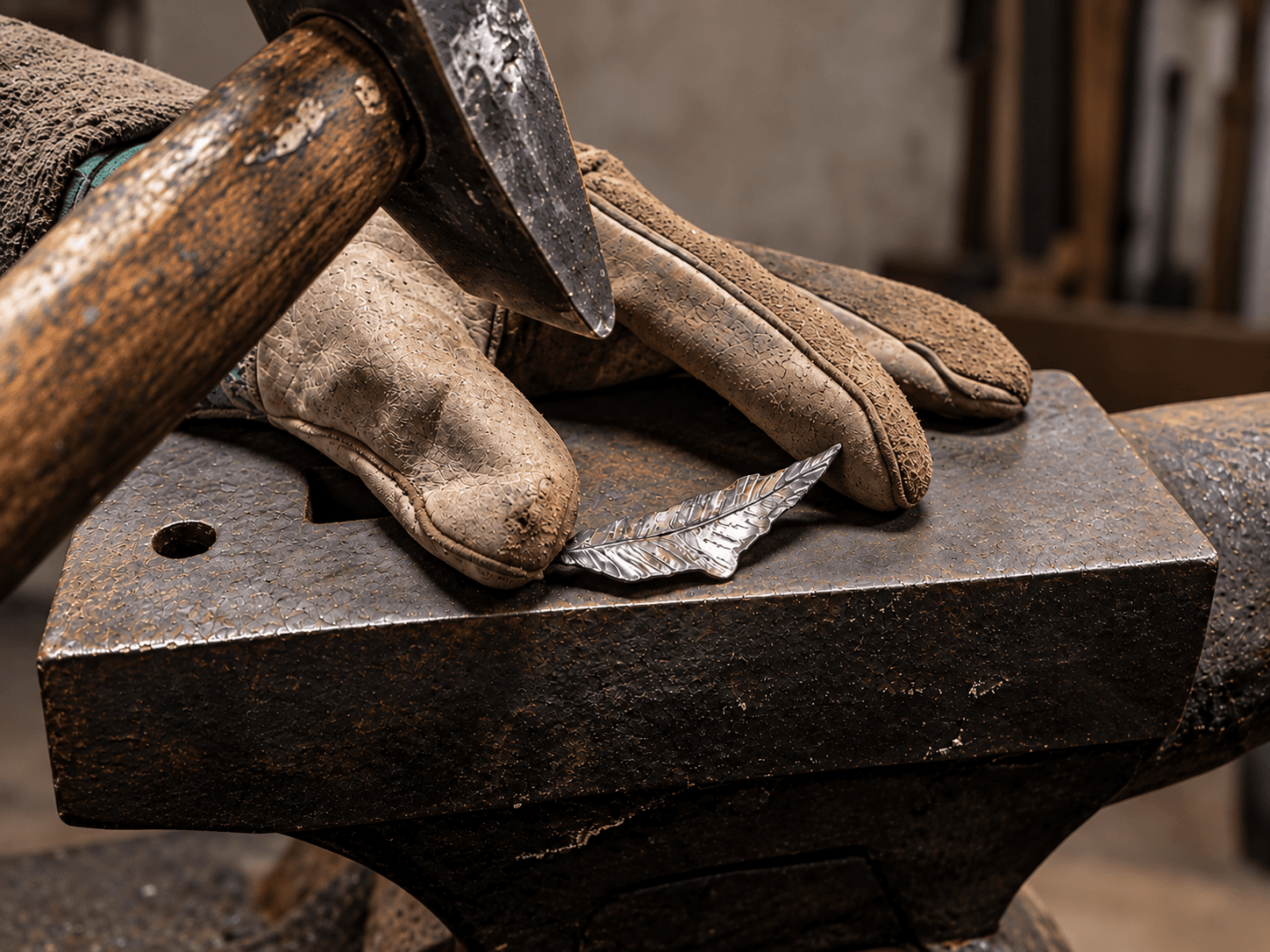 Hand-forging an iron leaf on an anvil